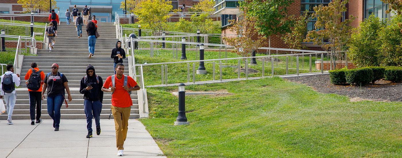 Students walking to and from class via the stairs by the Gira Center